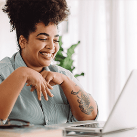 Business leader sitting at computer screen smiling