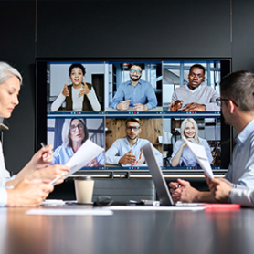 Image of corporate IT team meeting with leadership via hybrid work.