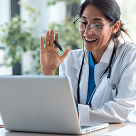 Doctor waving at telehealth patient on a computer