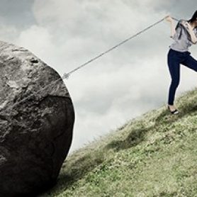 woman carrying debt boulder uphill