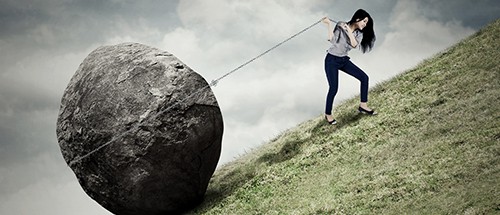 woman carrying debt boulder uphill