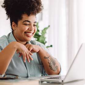 Business leader sitting at computer screen smiling